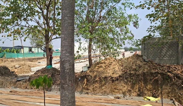 February 28, 2026: Construction update at Prestige Golden Grove showing site preparation, land leveling, concrete road work, temporary site storage, and the newly built compound wall.