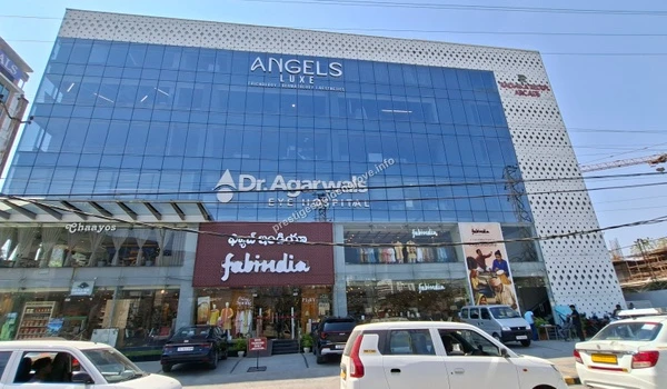 A vibrant commercial complex featuring Dr. Agarwals Eye Hospital, Fabindia, and Chaayos, representing the balanced lifestyle amenities around Prestige Golden Grove