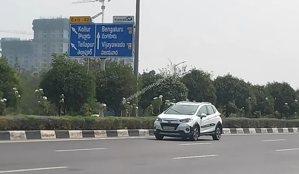 Strategic road signage at Kollur Junction showing directions to Bengaluru and Vijayawada, highlighting the excellent connectivity for residents of Prestige Golden Grove