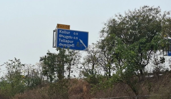 Clear highway signage indicating Exit 02 for Kollur and Tellapur, demonstrating the seamless Outer Ring Road connectivity to the Prestige Golden Grove project