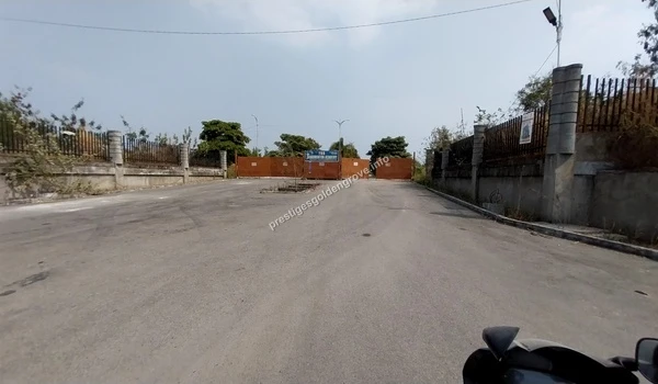 Wide angle view of the entrance road and main gate leading to the Prestige Golden Grove project site in Hyderabad