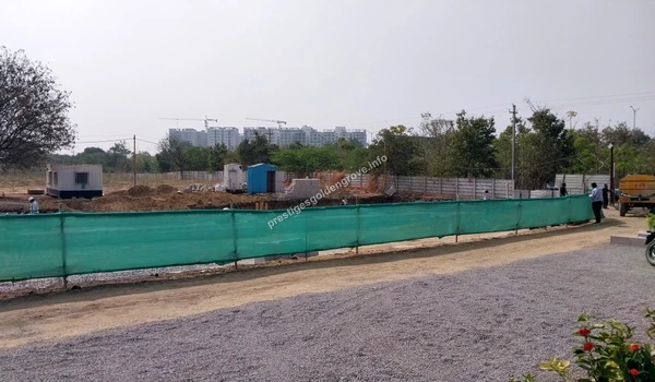 Temporary site offices and initial groundwork visible behind the green safety fencing at the Prestige Golden Grove project area