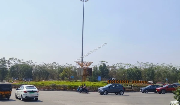Busy vehicular movement captured on March 03 , 2026 around a major landscaped roundabout with high-mast lighting, enhancing road safety near the Nehru Outer Ring Road and Prestige Golden Grove.