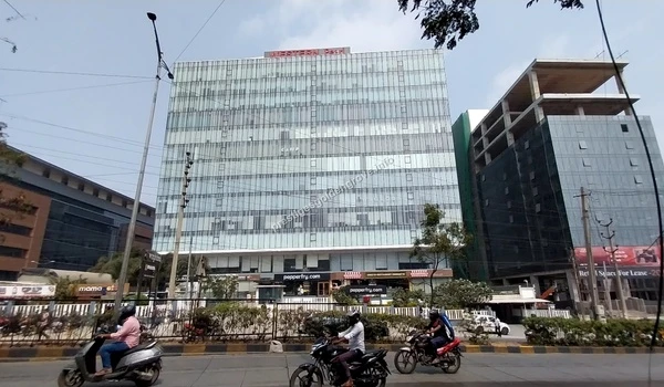 The sleek glass facade of Western Pearl in Hyderabad featuring prominent retail brands like Pepperfry located in close proximity to the Prestige Golden Grove community